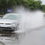 Samochód hamuje na mokrej autostradzie w deszczu, woda tryska spod kół