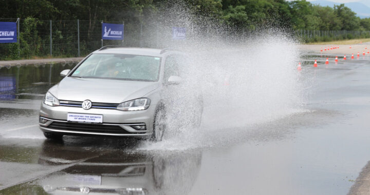 Samochód hamuje na mokrej autostradzie w deszczu, woda tryska spod kół