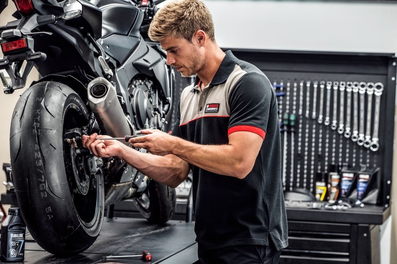 Proces czyszczenia tarczy hamulcowej szczotką drucianą i sprayem odtłuszczającym