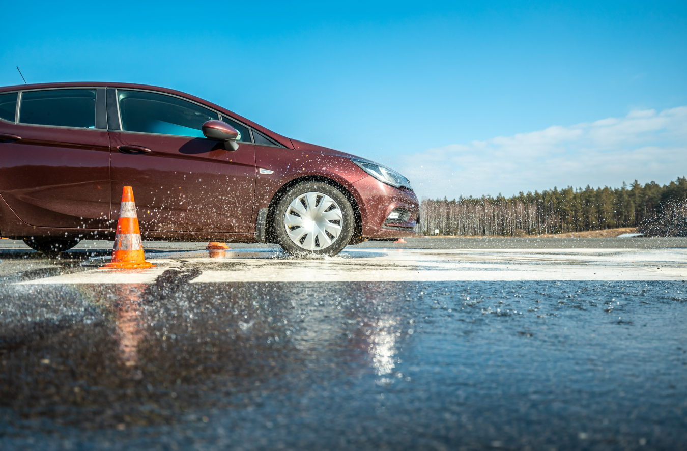 Kierowca wielokrotnie wciska pedał hamulca na śliskiej drodze w ulewie