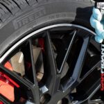 Samochód testowy hamujący na mokrej drodze z widocznymi śladami różnych opon